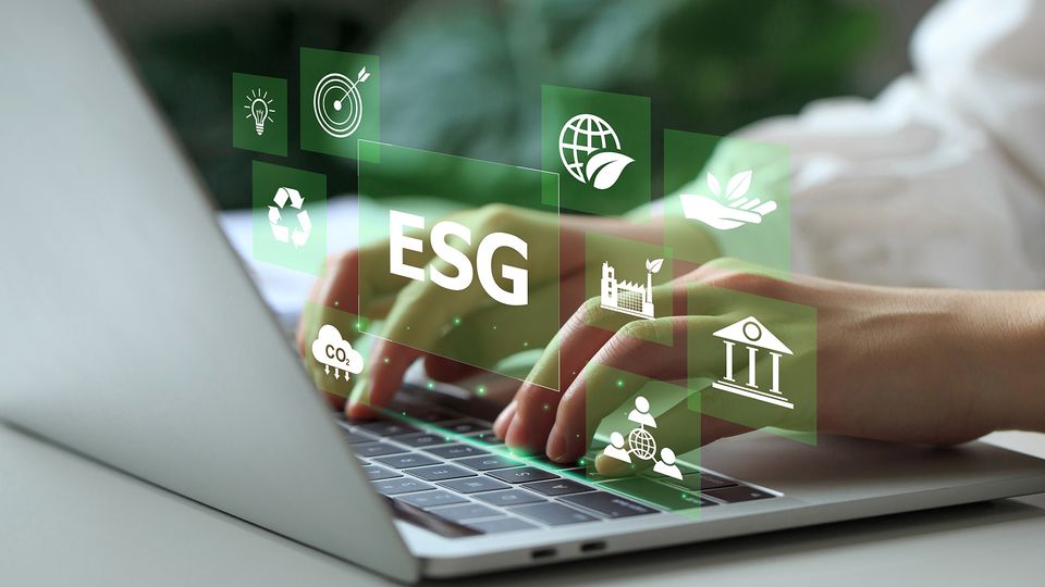 Hands typing on a laptop with floating green icons representing ESG concepts like sustainability, recycling, and carbon reduction.