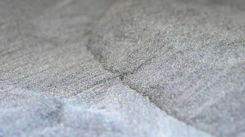 Close-up of a textured gray stone surface with fine grain patterns and subtle color variations.