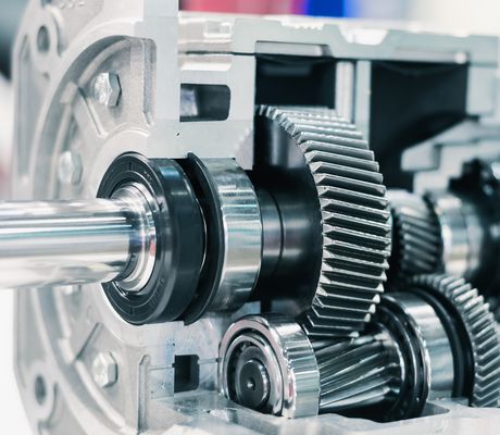 Close-up of a mechanical gearbox showing interlocking metal gears and shafts, highlighting engineering precision and machinery components.