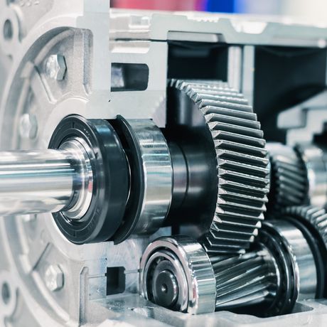 Close-up of a mechanical gearbox showing interlocking metal gears and shafts, highlighting engineering precision and machinery components.
