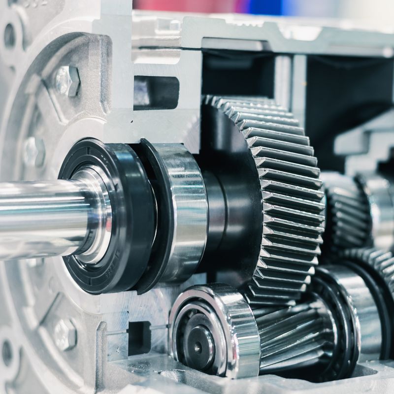 Close-up of a mechanical gearbox showing interlocking metal gears and shafts, highlighting engineering precision and machinery components.