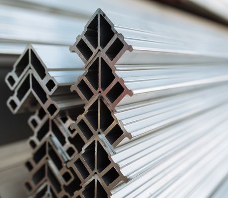 Close-up of stacked aluminum profiles with a geometric, cross-sectional design. The shiny, reflective surfaces emphasize their metallic texture.