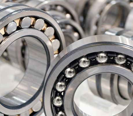 Close-up of multiple ball bearings and roller bearings, showcasing their metallic construction and circular design.
