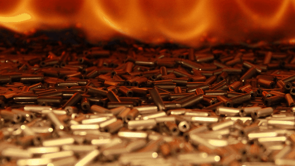 Close-up of cylindrical bullets scattered with a blurred fiery orange background.