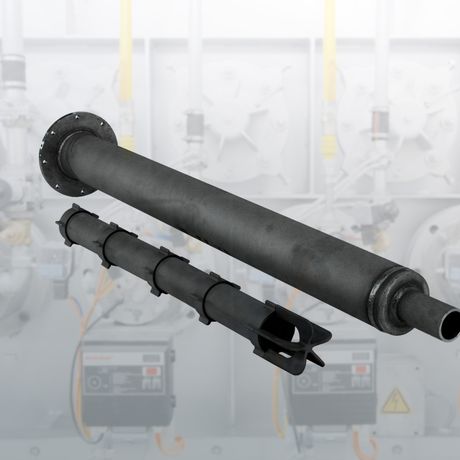A large black industrial pipe with multiple sections and a flange against a blurred industrial background with machinery.
