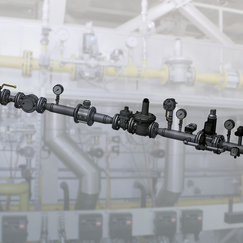 A large black industrial pipe with multiple sections and a flange against a blurred industrial background with machinery.