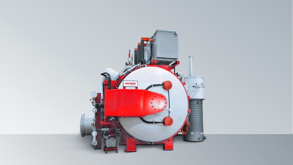 Industrial vacuum furnace with red accents and attached machinery, set against a gray gradient background.