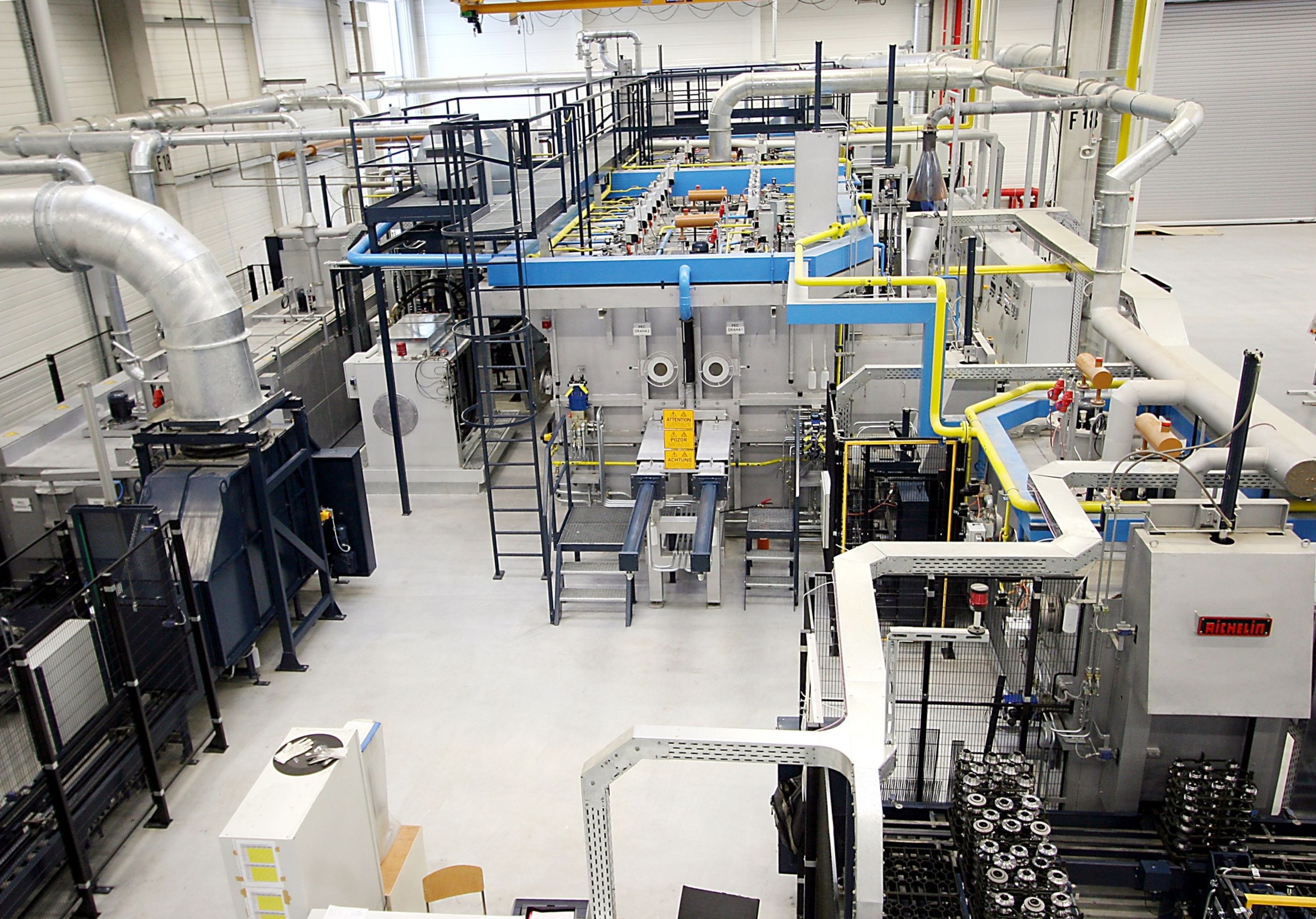 A large industrial facility with complex machinery, metal pipes, and platforms, possibly for manufacturing or processing purposes.