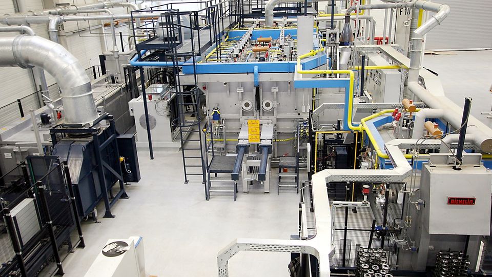 A large industrial facility with complex machinery, metal pipes, and platforms, possibly for manufacturing or processing purposes.