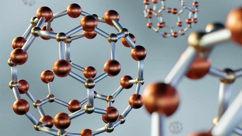 Close-up of molecular structures with brown spheres and silver rods, forming geometric patterns against a blurred gray background.