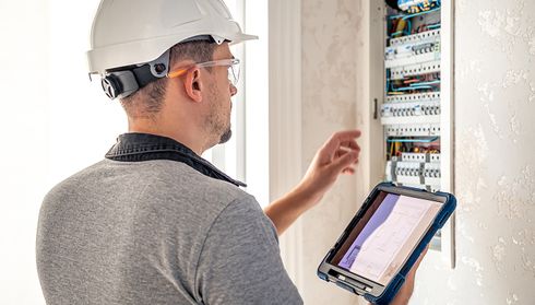 Electrician examines a circuit breaker panel