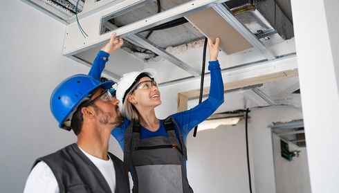 Technicians assembling frame for central air conditioning ducts