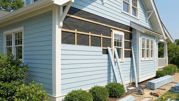Light blue fiber-cement siding under installation