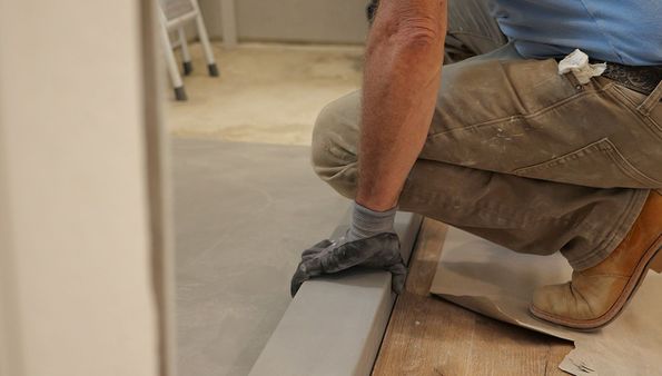 A person is smoothing a concrete surface with a tool