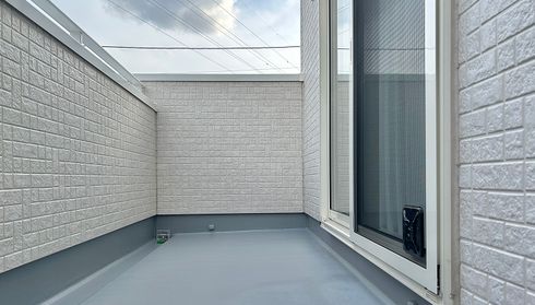 Light gray fiber-cement siding on a small balcony exterior wall