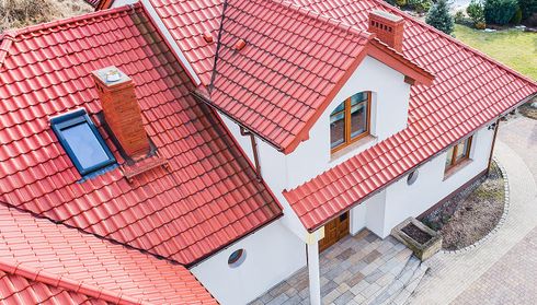 Red metal tile roof on house with skylights