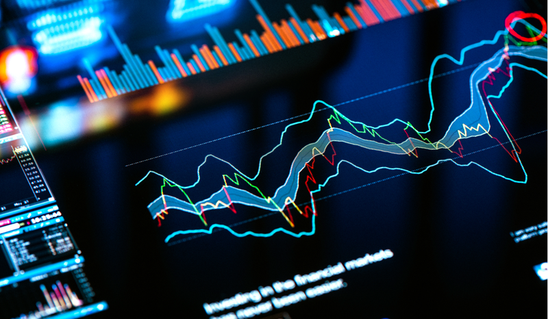 Colorful financial graphs and charts displayed on a digital screen, showing various data trends and analytics in a dark setting.