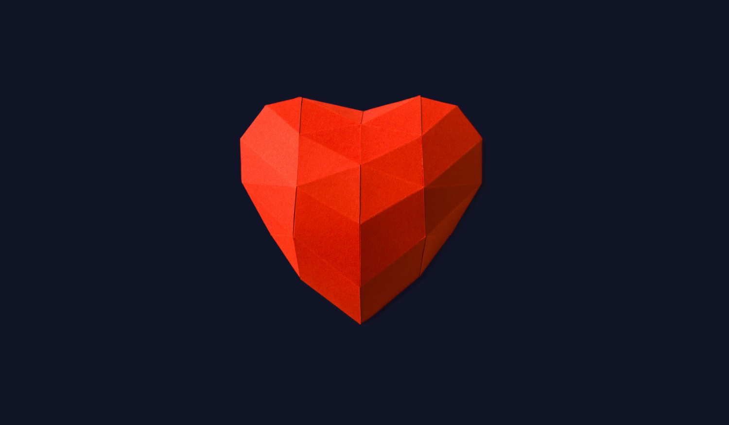 Geometric red heart against a dark blue background, featuring angular facets and a 3D appearance.
