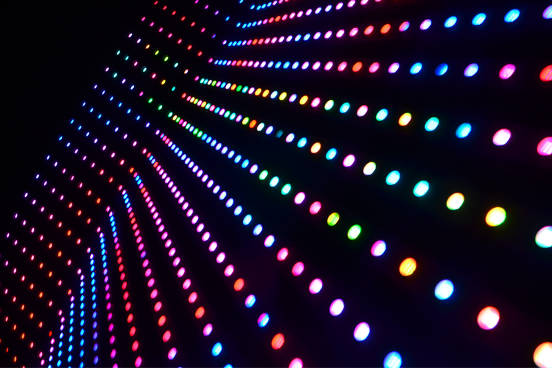 Rows of colorful LED lights in a dark setting, creating a vibrant, diagonal pattern with shades of red, blue, green, and purple.