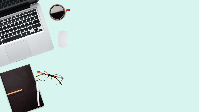 Open laptop, coffee cup, mouse, notebook, pen, and glasses arranged on a light blue surface.