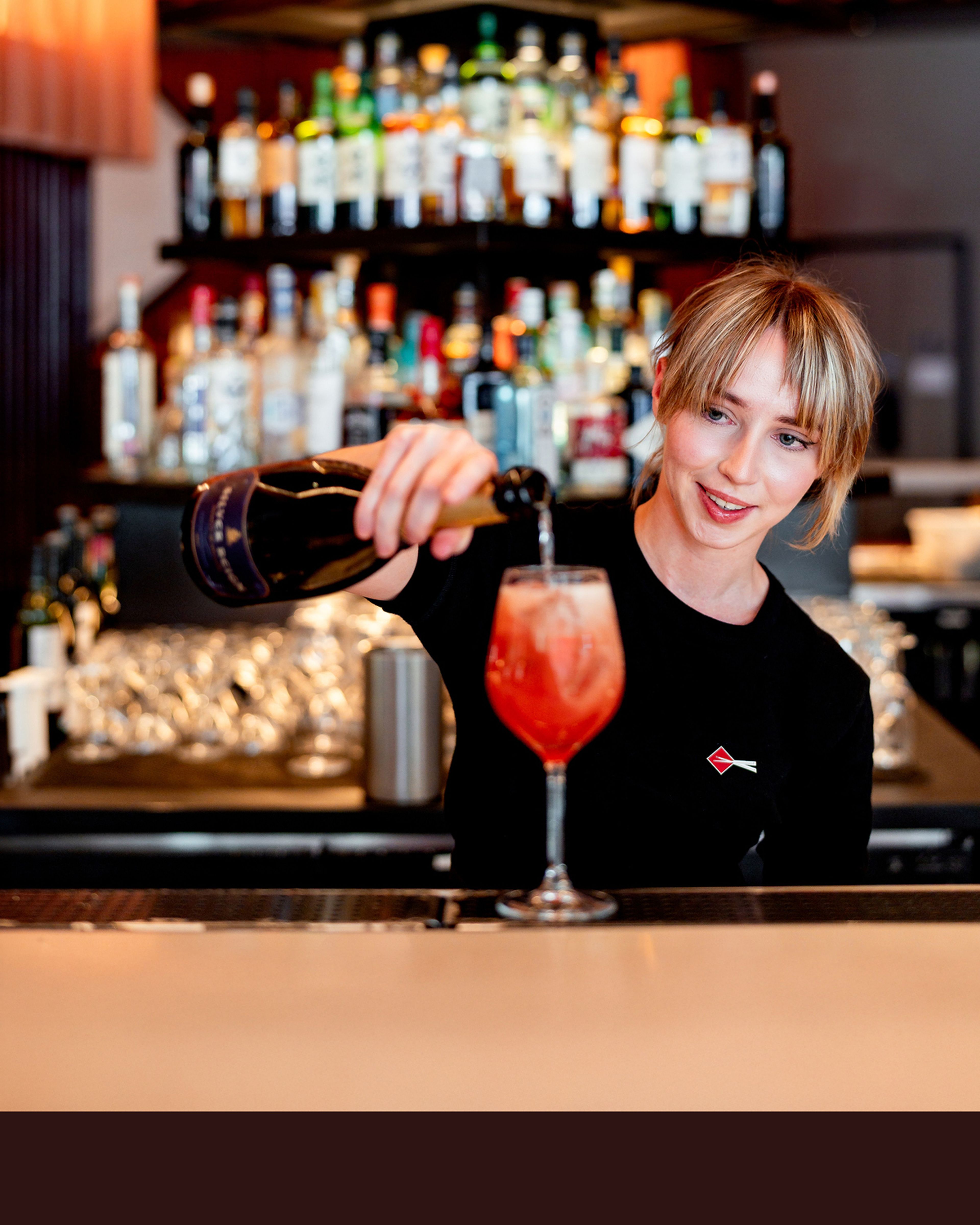 Smily bartender serving drinks at a cool trendy Shoreditch bar