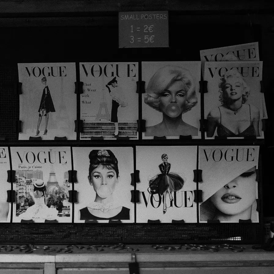 Black and white display of Vogue magazine covers featuring iconic fashion photography and portraits, with price sign above.