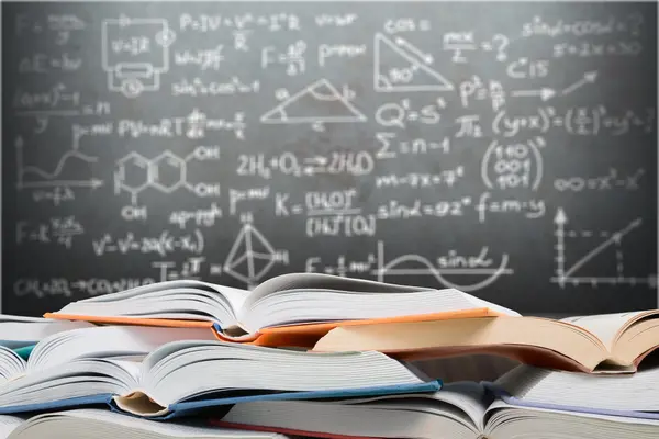Offene Bücher, die vor einer Tafel mit mathematischen Gleichungen und geometrischen Diagrammen gestapelt sind.