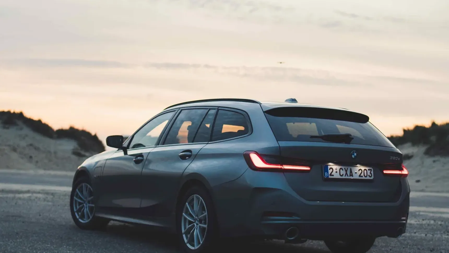 2024 BMW 320e Touring seaside iphone background rear sunset