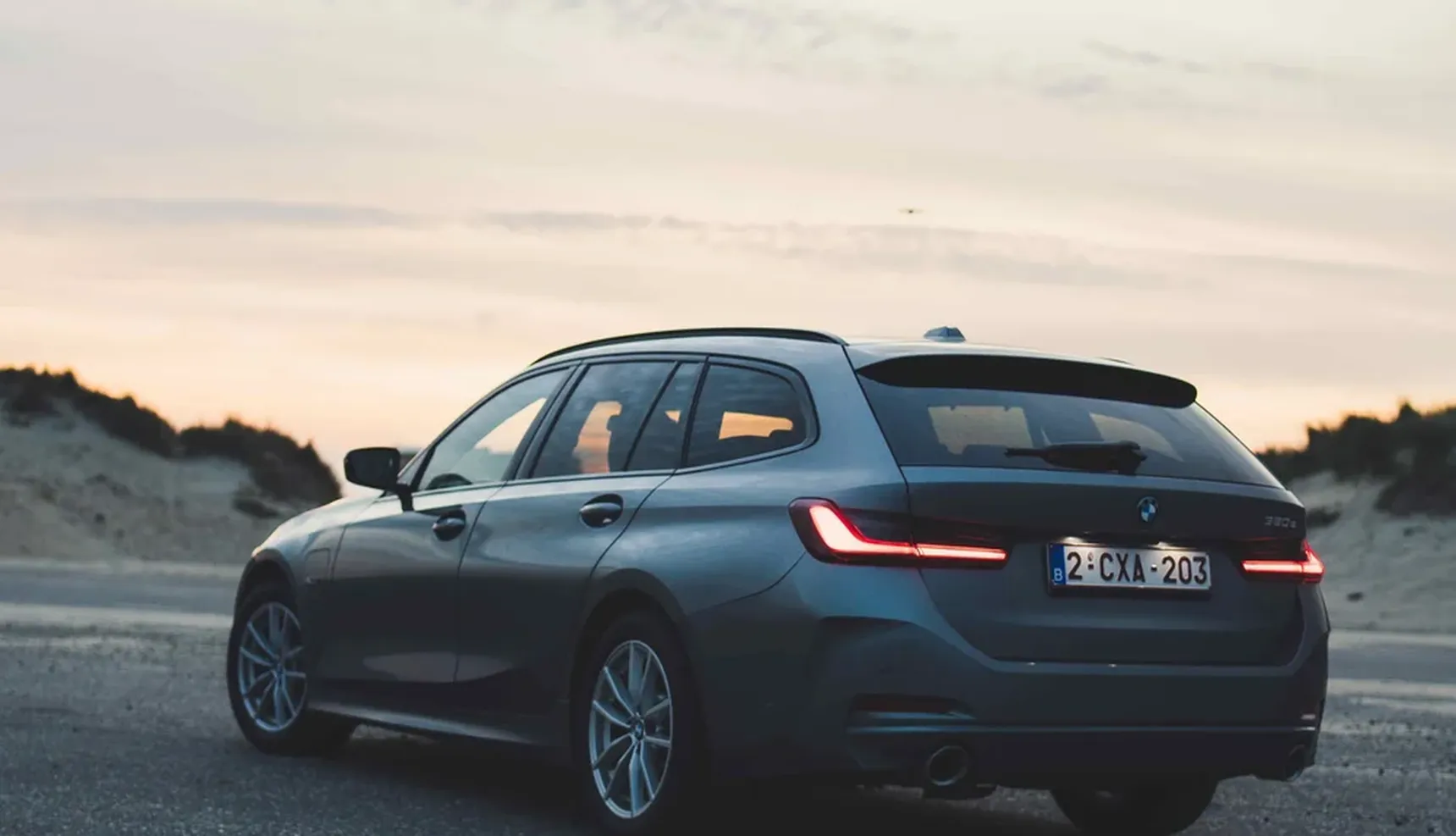 2024 BMW 320e Touring seaside iphone background rear sunset