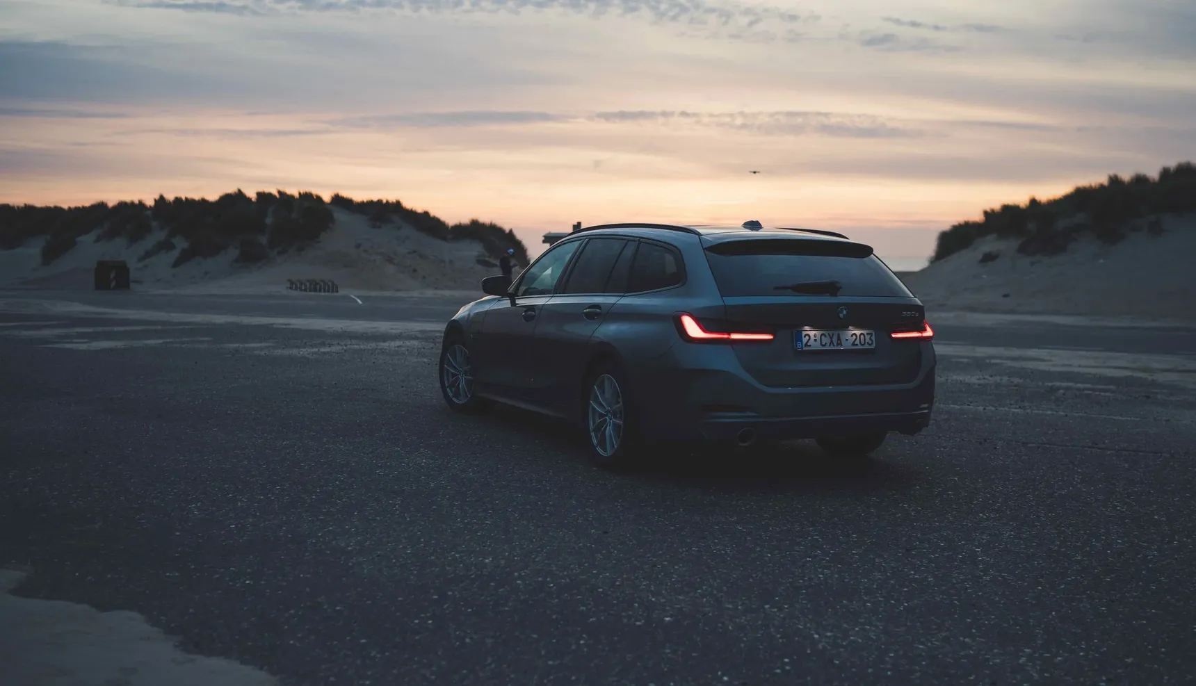 2024 BMW 320e Touring sunset beach rear 3/4