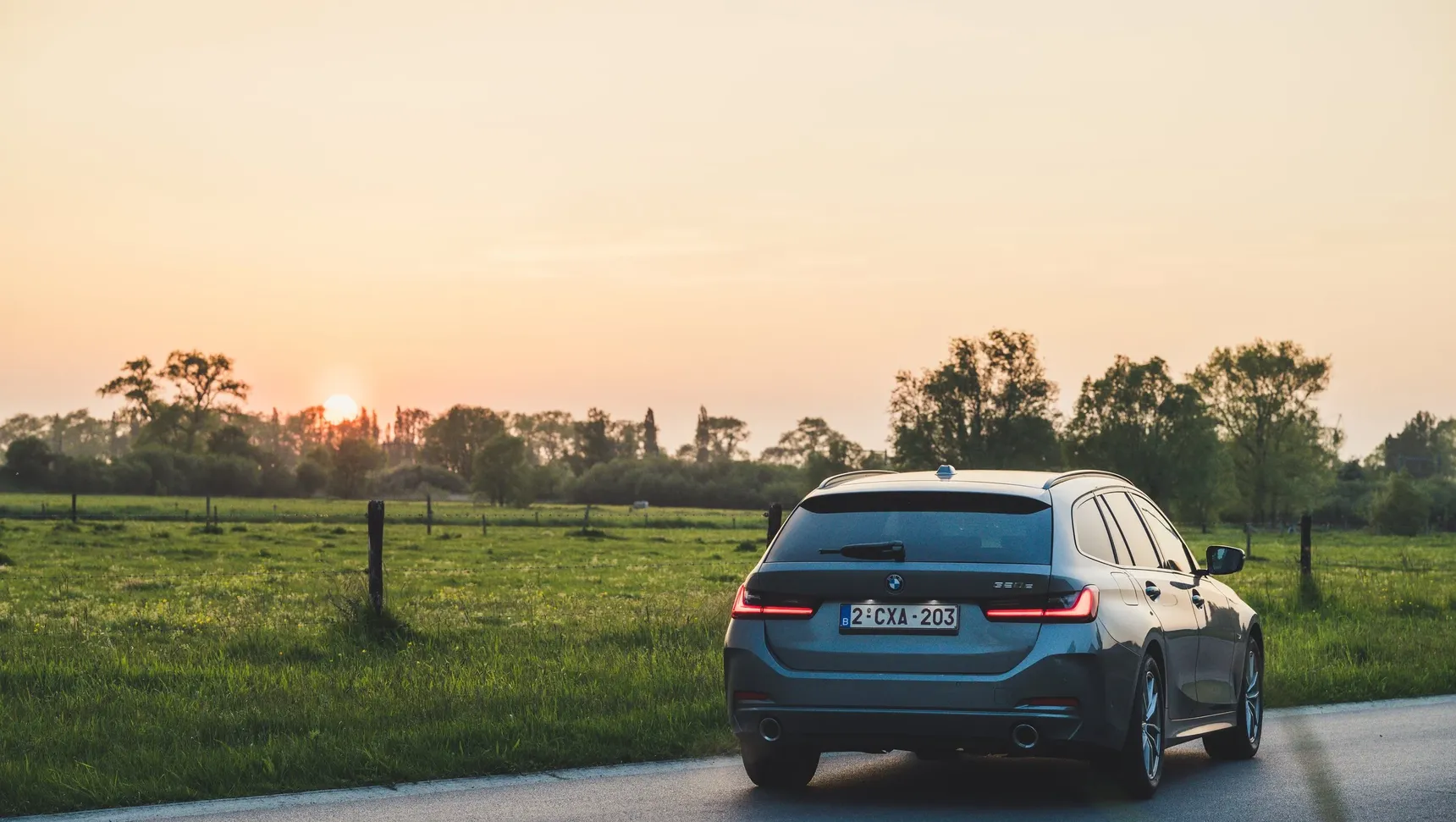 2024 BMW 320e Touring rear sunset grass fields