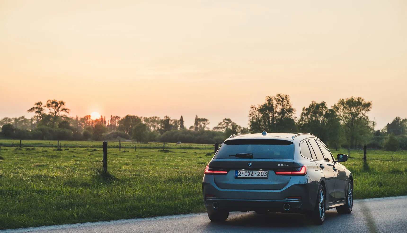 2024 BMW 320e Touring rear sunset grass fields