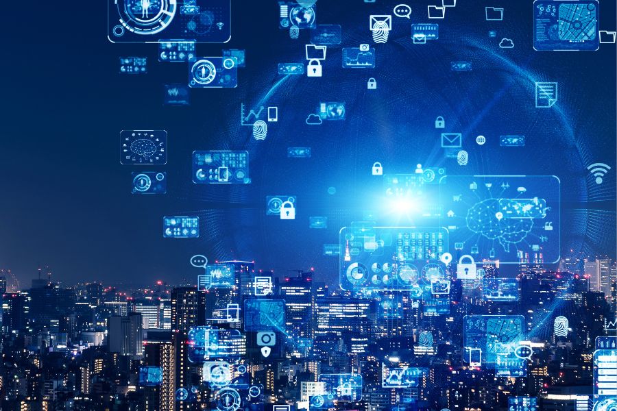 Futuristic cityscape at night with digital icons and blue holographic elements overlaying the skyline, representing technology and connectivity.
