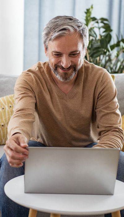 Man sitting on the couch and looking at the laptop