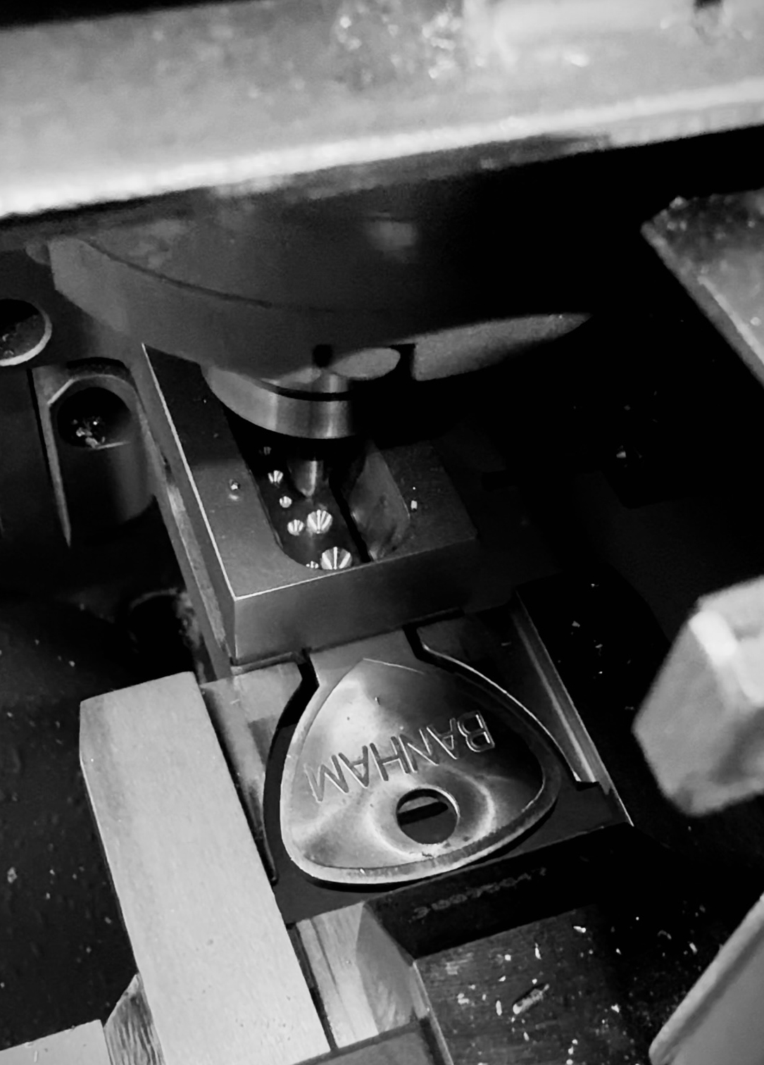 Polished key component being machined, with "BANHAM" engraved on the surface.Expertly cut all models of Banham keys using Banham's premium quality key blanks · Exclusively cut Banham's patent protected Mark III keys through.