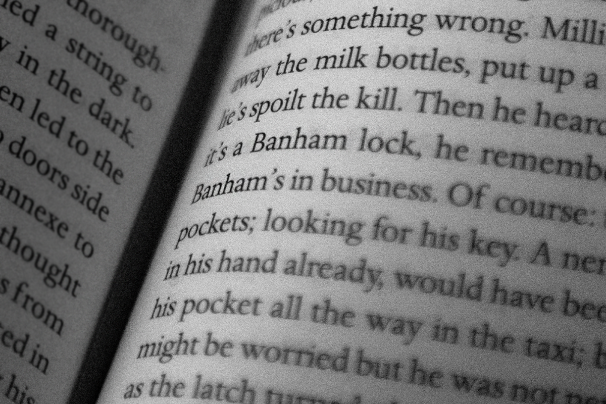 Close-up of an open book showing partially visible text detailing a narrative with words like "Banham lock" and "pockets" in focus.