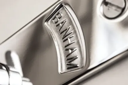 Close-up of a chrome Banham door lock. The brand name "BANHAM" is engraved on a metallic surface with a sleek and polished appearance.