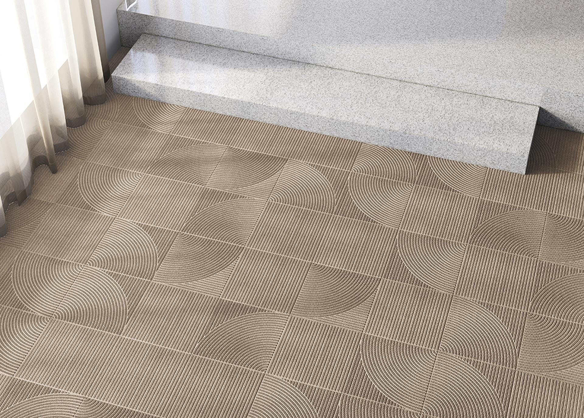 Patterned brown tiles with circular designs on a floor next to granite steps and sheer curtains.
