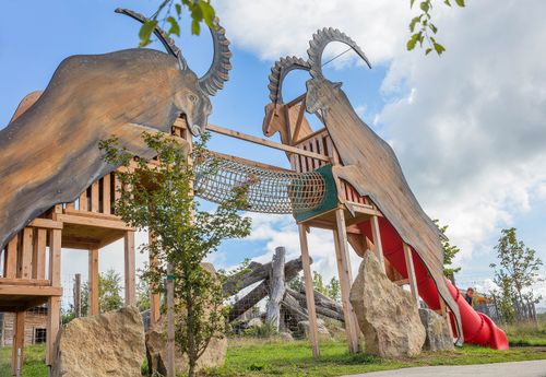 Steinböcke im IKUNA Kinder spielen auf der Steinbock-Spielstation im IKUNA Naturresort – Kletterspaß und Abenteuer für die ganze Familie.