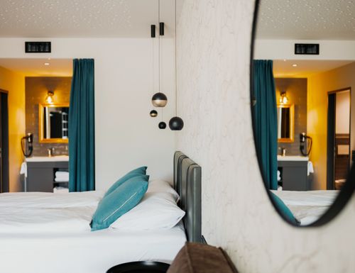 Gemütlicher Schlafbereich der Garden Rooms im IKUNA Naturresort – moderne Unterkunft für erholsame Übernachtungen in Natternbach, Oberösterreich.
