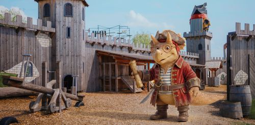 IKUNĚ Přírodní resort Kreslený dinosaurus v pirátském převleku stojí sebevědomě ve středověké dřevěné pevnosti. Drží svitek, má na sobě červený kabát a klobouk a vyzařuje z něj dobrodružný duch.