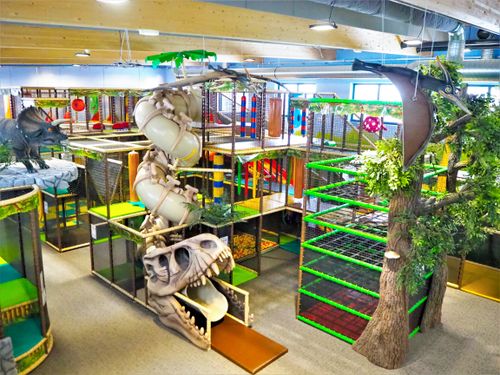IKUNA Naturresort Vnitřní herní areál s dinosauří tematikou. Součástí areálu v IKUNA Naturresort je velká skluzavka vedoucí skrz lebku tyranosaura, barevné prolézačky a realisticky vypadající dinosauři v živém, dobrodružném prostředí.