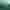 Eine Frau in weißer Kleidung rutscht fröhlich auf einem aufblasbaren Reifen eine grüne Kunststoffrutsche an einem Hang hinunter, im Hintergrund sind einige Bäume und ein bewölkter Himmel zu sehen.