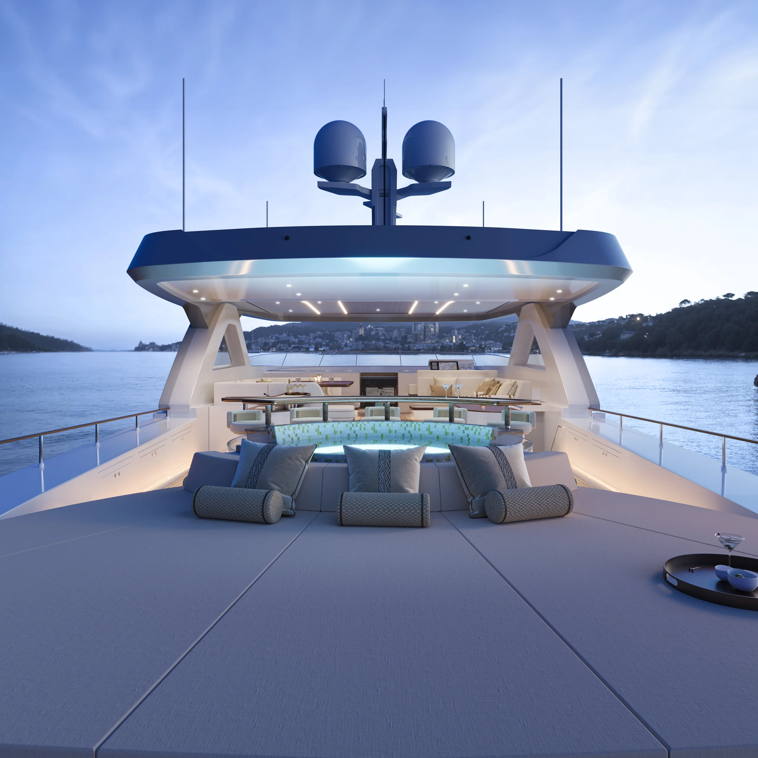 Luxurious yacht deck at sunset, featuring a spacious lounging area with a central pool and modern seating, surrounded by calm water and distant hills.