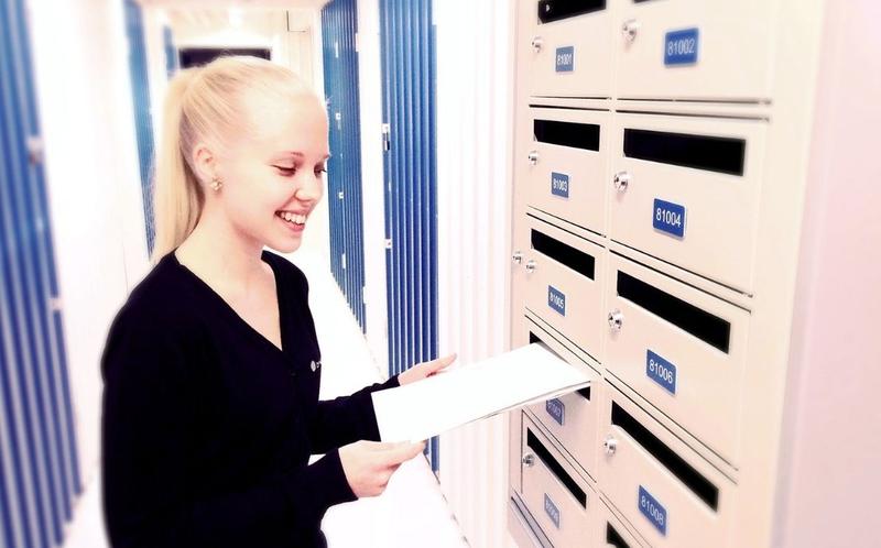 Woman putting a letter in a mailbox – Cityvarasto rentable post boxes