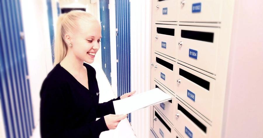 Nainen laittaa kirjeen Cityvaraston postilokeroon - Cityvaraston vuokrattavat postilokerot