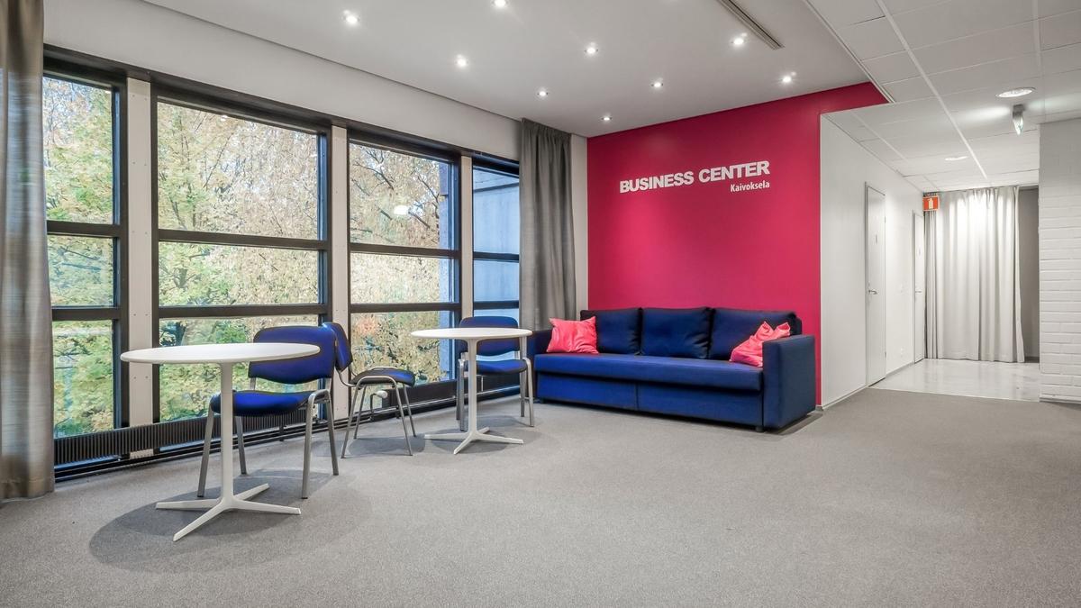 Nainen puhuu puhelimeen Cityvaraston toimistohotellissa – Cityvarasto Business Center – täyden palvelun toimistohotelli yrityksille