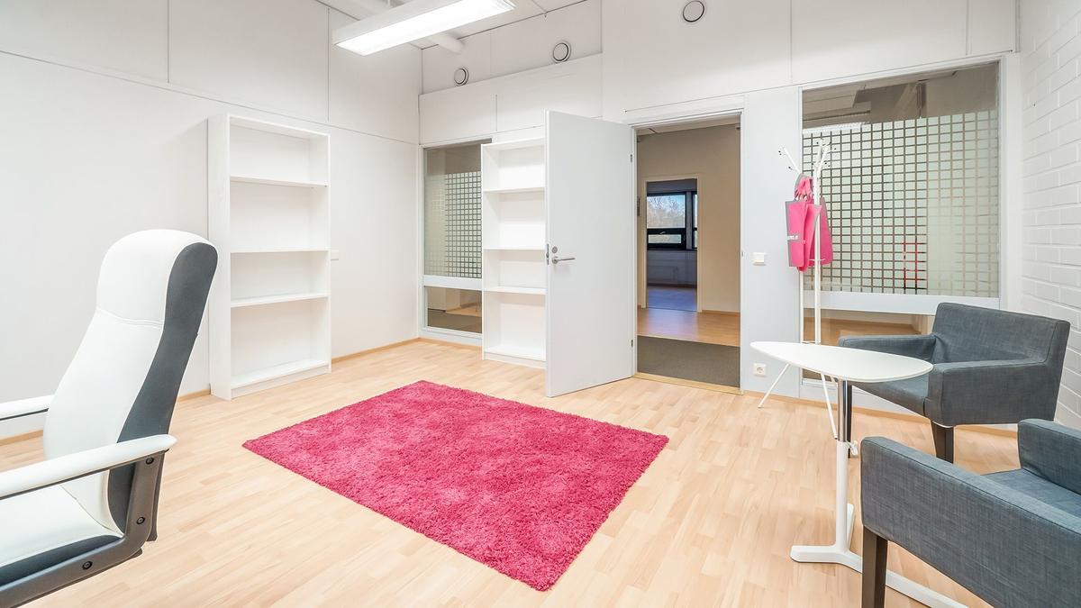 Cityvaraston yrityksille vuokrattava toimistohuone – pinkki matto, tuolit ja kirjahyllyt toimistossa