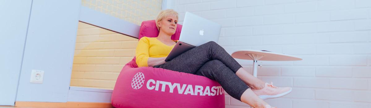 Nainen tietokoneen kanssa Cityvaraston yrityksille ja organisaatioille vuokrattavassa toimitilassa