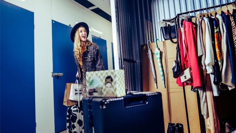 Woman finding space for clothes and belongings in a Cityvarasto small storage unit – affordable storage space for rent for moving and storage
